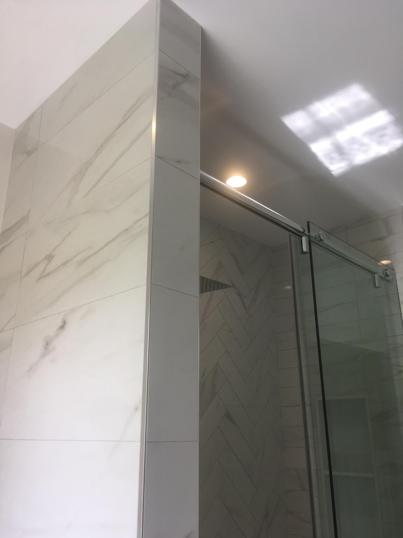 marble floor to ceiling wall separating toilet and shower