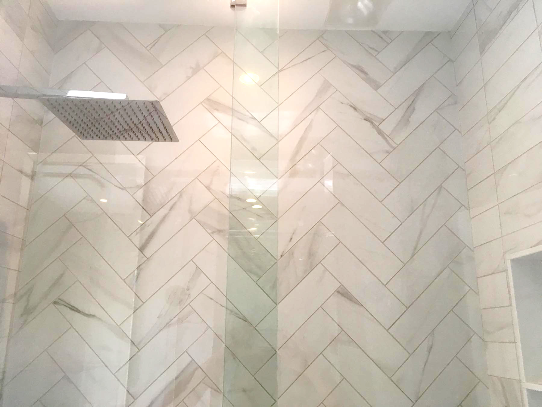 herringbone tile pattern in shower renovation with a rain shower head